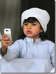 A Saudi child uses his mobile phone to take pictures of colourful roosters during a chicken beauty contest eastern Saudi city of Qatif, on May 02, 2008. AFP PHOTO/STR (Photo credit should read -/AFP/Getty Images)